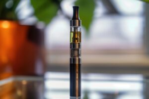 Gros plan sur une cigarette électronique utilisée pour vapoter du CBD.
